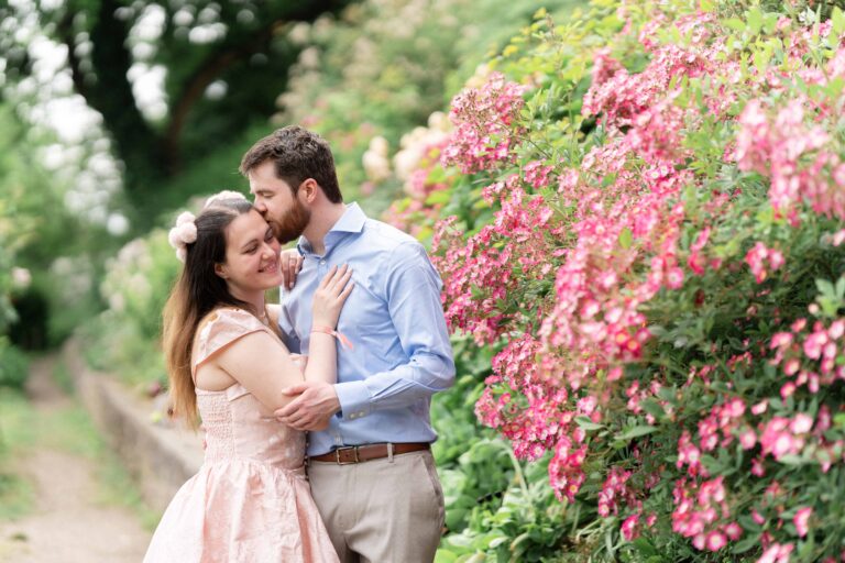 engagement session couple pink flowers pink dress kiss
